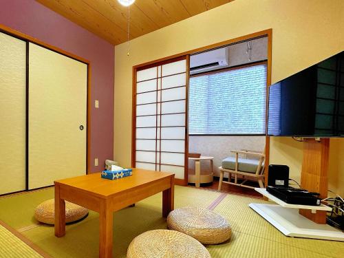 a living room with a table and chairs and a window at HANA Inn 1m to Metro Large 2DK Tennoji 4m Shinsaibashi 13m 3F No Lift in Osaka