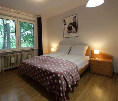 a bedroom with a bed and two lamps and a window at Ferienwohnung Am Hohen Berge in Lauenburg