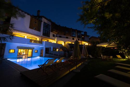 a house with a swimming pool at night at Gran Baita Hotel & Wellness in Courmayeur