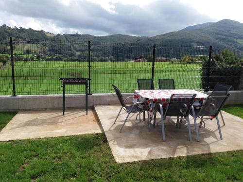 a table and chairs with a view of a field at La Casuca in Rasines