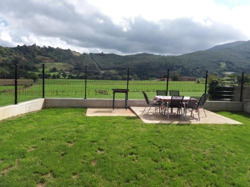 a patio with a table and chairs in the grass at La Casuca in Rasines