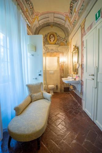 a bathroom with a couch and a sink and a toilet at Hotel Villa Sermolli in Borgo a Buggiano