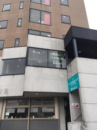 a building with a sign in front of it at Hotel Tajimi Hills Riverside in Tajimi