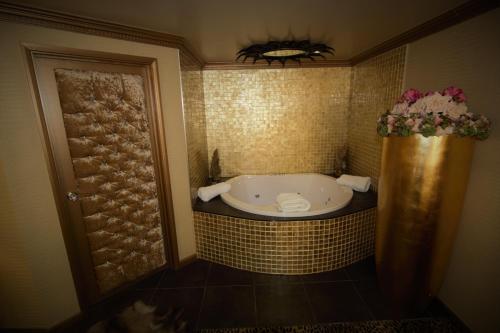 a bath tub in a bathroom with a tiled wall at Who'd A Thought It in Lenham