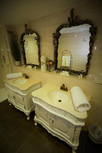 a bathroom with two sinks and two mirrors at Who'd A Thought It in Lenham