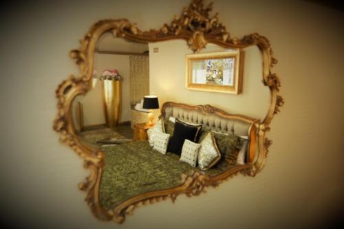 a mirror on a wall with a bed with pillows at Who'd A Thought It in Lenham