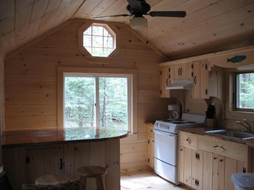 a kitchen with wooden walls and a ceiling fan at Okie Dokie Cabins in Tamworth