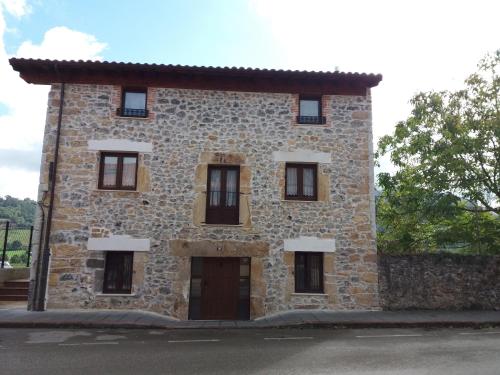 a large stone building with windows on the side at La Casuca in Rasines