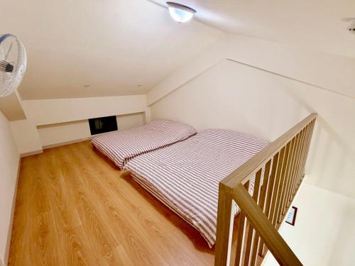 a attic room with two beds and a fan at 宜蘭好窄平價民宿 in Zhuangwei
