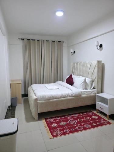 a bedroom with a large bed and a red rug at LJ Homes in Nairobi
