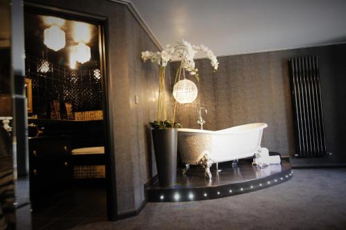 a bathroom with a tub with a plant in it at Who'd A Thought It in Lenham