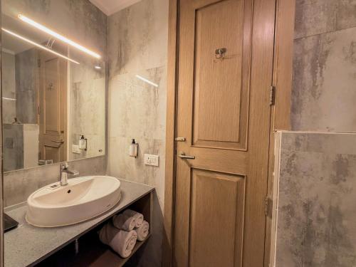 a bathroom with a sink and a wooden door at Spree Hotel Kriday Rajpur Road Dehradun in Dehradun