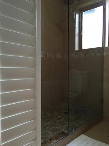 um chuveiro com uma porta de vidro na casa de banho em Keurbooms River Lodge 1311 em Plettenberg Bay
