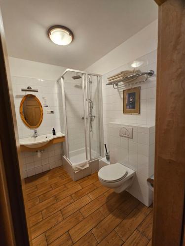 a bathroom with a shower and a toilet and a sink at Folwark Historic Hotel in Warsaw