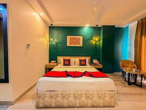 a bedroom with a large bed with green walls at Spree Hotel Kriday Rajpur Road Dehradun in Dehradun