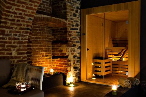 a room with a brick wall with a fireplace at Réva Resort in Monforte dʼAlba