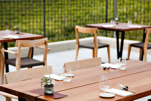 a wooden table with chairs and wine glasses at Réva Resort in Monforte dʼAlba