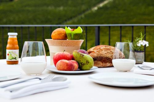 a table with a plate of fruit and a basket of bread at Réva Resort in Monforte dʼAlba
