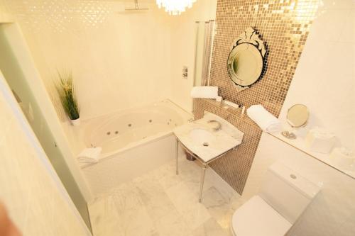 a bathroom with a tub and a toilet and a sink at Who'd A Thought It in Lenham
