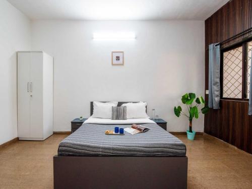 ein Schlafzimmer mit einem Bett und einer weißen Wand in der Unterkunft Palette Mountain Mist Villa | 2BHK | Jacuzzi | Pool | Lonavala in Lonavla