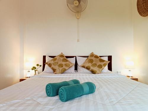 a white bed with two blue towels on it at Grand Apsara Residence in Siem Reap