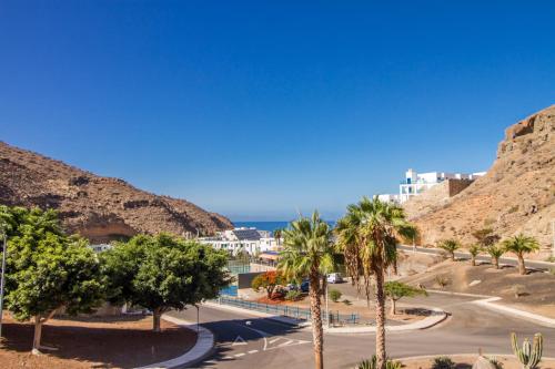 a view of a street with palm trees and a mountain at Granada II Apartments in Puerto Rico de Gran Canaria