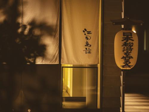 a sign on the side of a building with a window at Etajimasou Hotel & SPA Hiroshima in Etajima