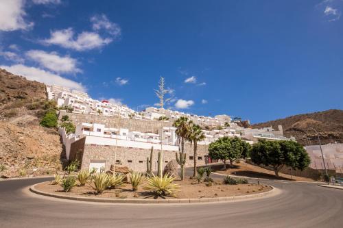 a winding road in front of a building on a mountain at Granada II Apartments in Puerto Rico de Gran Canaria