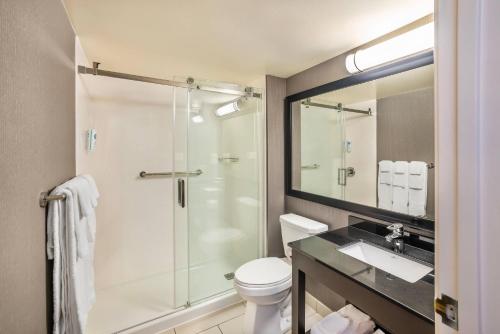 a bathroom with a shower and a toilet and a sink at Comfort Inn Moncton East in Moncton