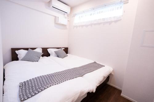 a bedroom with two beds and a window at 新築Sunbright Asakusa 101 in Tokyo