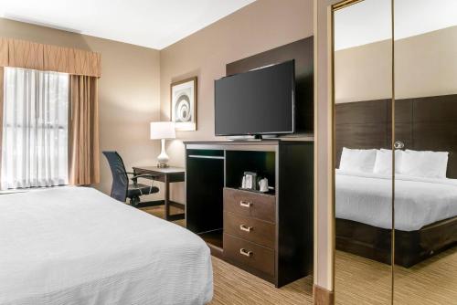 a hotel room with a bed and a flat screen tv at Quality Inn & Suites Monroe in Monroe