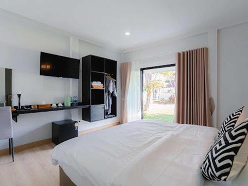 a bedroom with a large white bed and a window at Villanin Hotel & Spa Golden Triangle in Ban Wiang Nuea