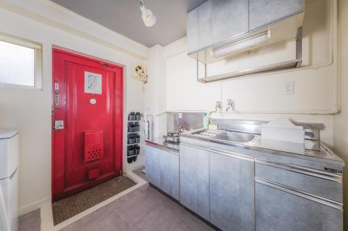 a red door in a kitchen with a red counter at Comfy Stay Tokiwadai 2minute walk from Tokiwadai Station Ikebukuro 9min Shinjuku 14min Shibuya 18min Max 4guests Many restaurants nearby hot spring Shrine nearby in Tokyo