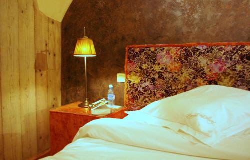 a bedroom with a bed and a table with a lamp at B&B Canal Deluxe in Bruges
