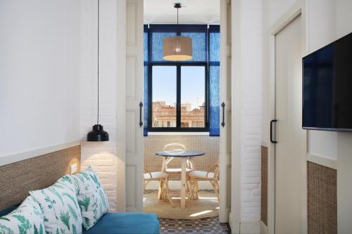 a living room with a table and a window at Hotel Casa Bonay & Spa in Barcelona