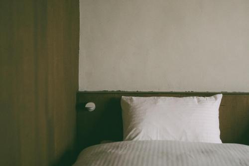 a bedroom with a bed with a white pillow at ONYO Hotel and Lounge in Ueda