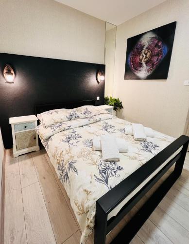a bedroom with a large bed with a black headboard at Apartament Na Starówce in Kłodzko