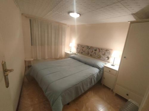 a bedroom with a bed and two night stands and two lamps at Cal Pataqué, house in Arnes in Arnés