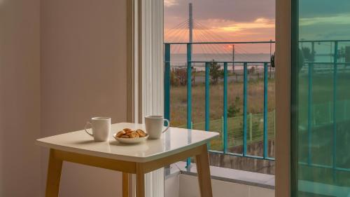 a table with two cups and a bowl of nuts on a balcony at Gyeongju Gamposole Pension in Gyeongju