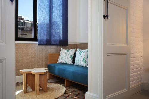 a blue couch in a room with a window at Hotel Casa Bonay & Spa in Barcelona