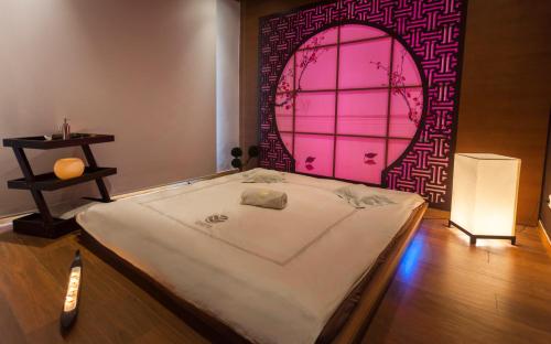 a bed in a room with a pink door at La Cigale Tabarka in Tabarka
