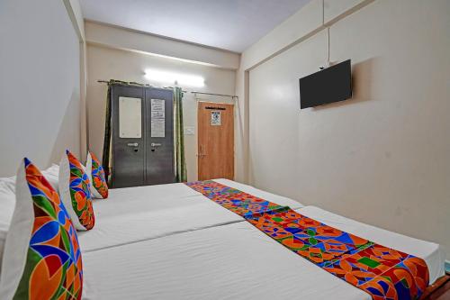 a bedroom with a bed with a television on the wall at Via Lords inn in Bhopal