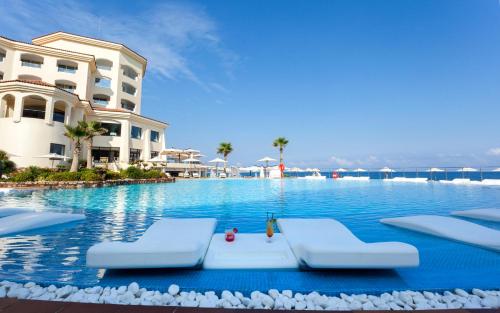 a swimming pool with lounge chairs and a hotel at La Cigale Tabarka in Tabarka