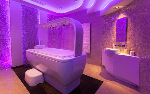 a purple bathroom with a toilet and a sink at La Cigale Tabarka in Tabarka