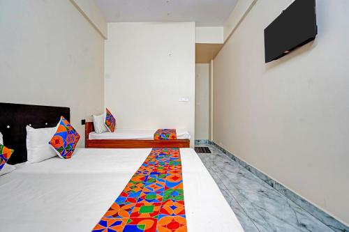 a hotel room with a bed with a colorful carpet at Via Lords inn in Bhopal