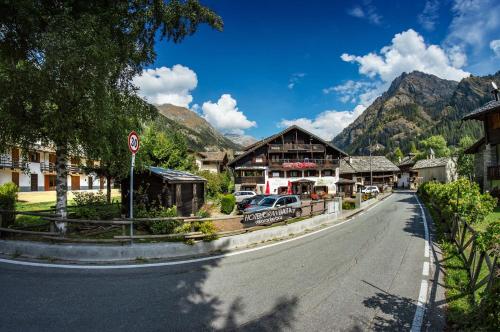 a street in a village with mountains in the background at Hotel Gran Baita in Gressoney-Saint-Jean