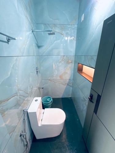 a bathroom with a white toilet in a room at Skyscenic Munnar in Munnar