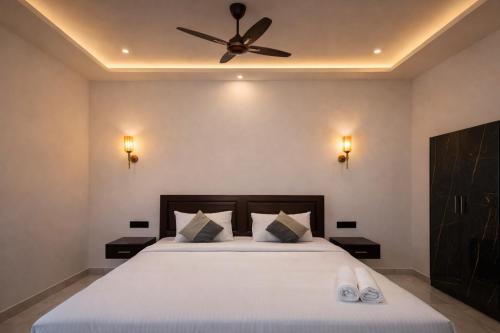 a bedroom with a bed with a ceiling fan at Skyscenic Munnar in Munnar