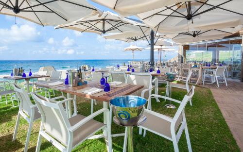 a restaurant with white chairs and tables and the ocean at La Cigale Tabarka in Tabarka