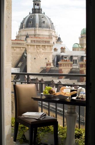 a table with a plate of food on a balcony at Grand Hotel Saint Michel in Paris